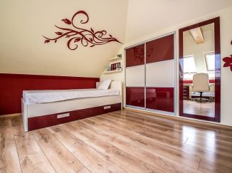 Podkrovná červená detská izba so vstavanou skriňou a posteľou