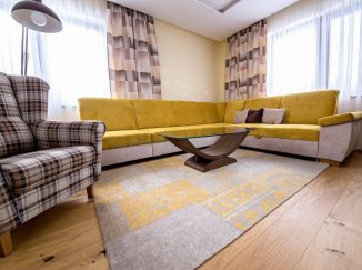 Obývačka so žltou sedačkou a dreveným stolom