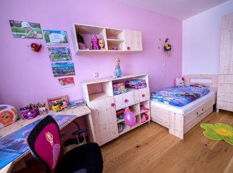 Ružová detská izba s dreveným nábytkom