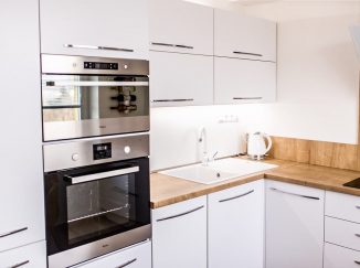 Biela moderná kuchyňa s drevom do L